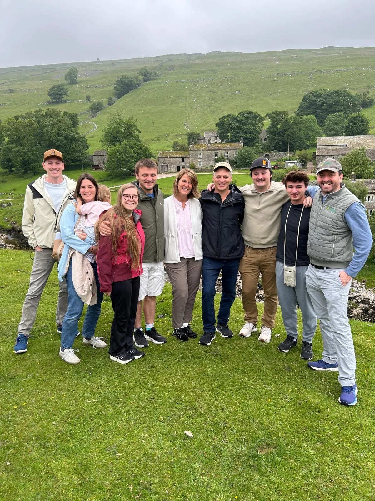 A group of Expedition Yorkshire guests together in a green Yorkshire Dales valley with a stone barn and fellside behind, on a private day tour