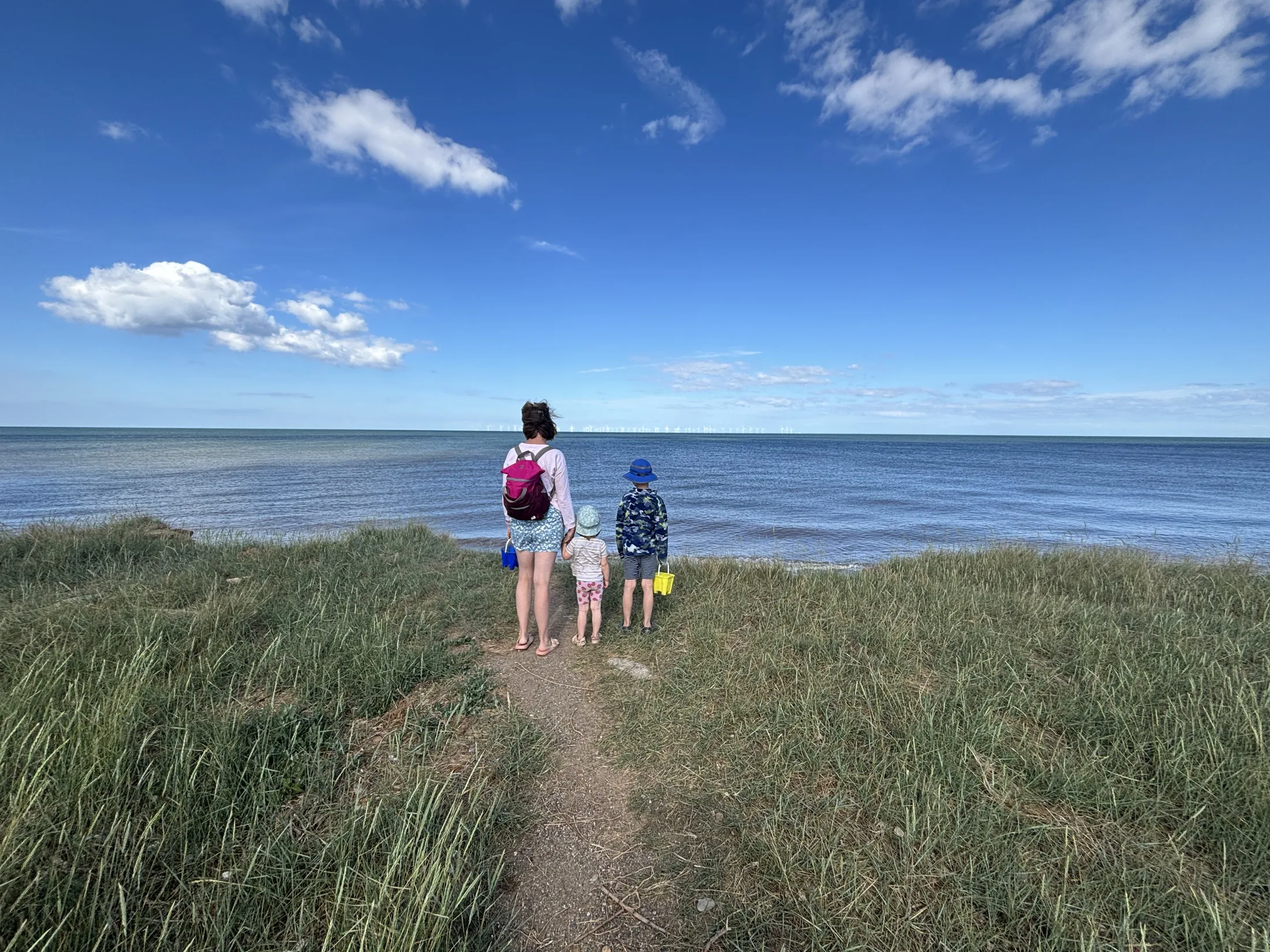 A family looking out to sea on a coastal stop during the private York to Edinburgh scenic transfer